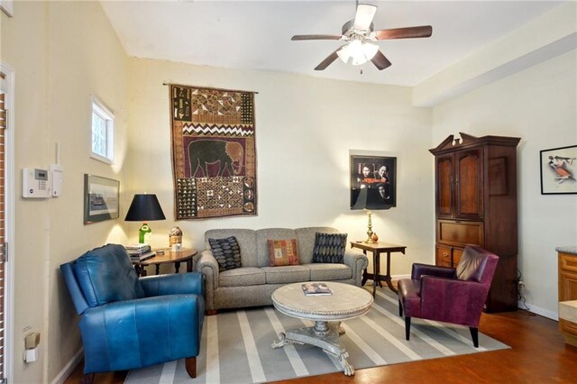 living room featuring ceiling fan and dark hardwood / wood-style floors