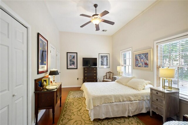 bedroom with dark hardwood / wood-style floors, ceiling fan, and a closet