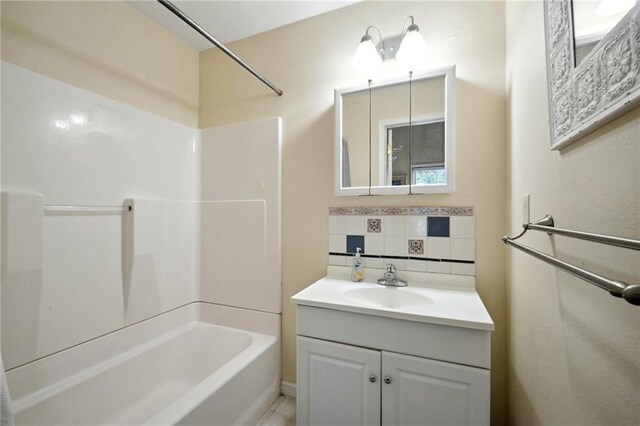 bathroom featuring vanity,  shower combination, and tasteful backsplash