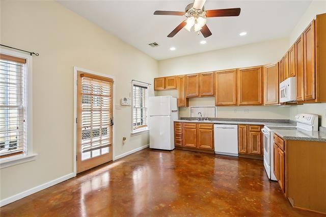 kitchen with white appliances, ceiling fan, and sink