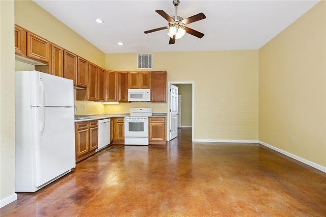 kitchen featuring white appliances, concrete flooring, and ceiling fan