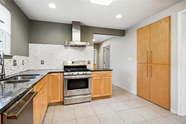 kitchen featuring sink, tasteful backsplash, wall chimney range hood, stainless steel appliances, and dark stone counters