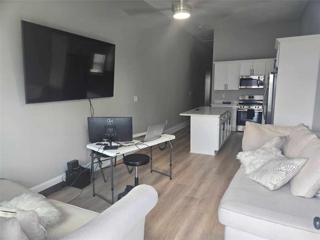 living room with light hardwood / wood-style floors and ceiling fan