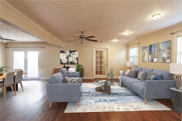 living room with ceiling fan, a textured ceiling, dark hardwood / wood-style floors, and ornamental molding