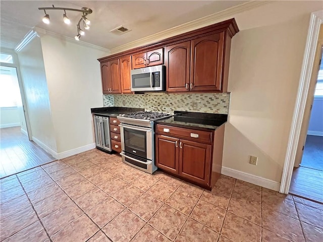 kitchen with light hardwood / wood-style flooring, backsplash, appliances with stainless steel finishes, and crown molding