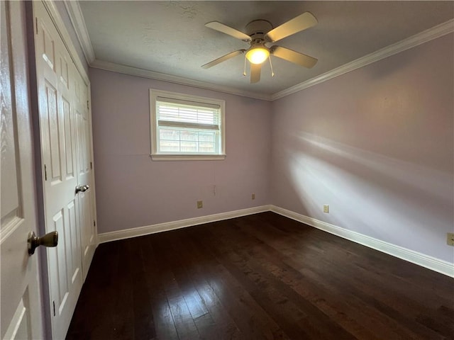 empty room featuring ornamental molding, ceiling fan, and dark wood-type flooring