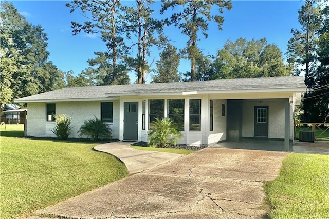 ranch-style house with a front lawn, a carport, and central air condition unit