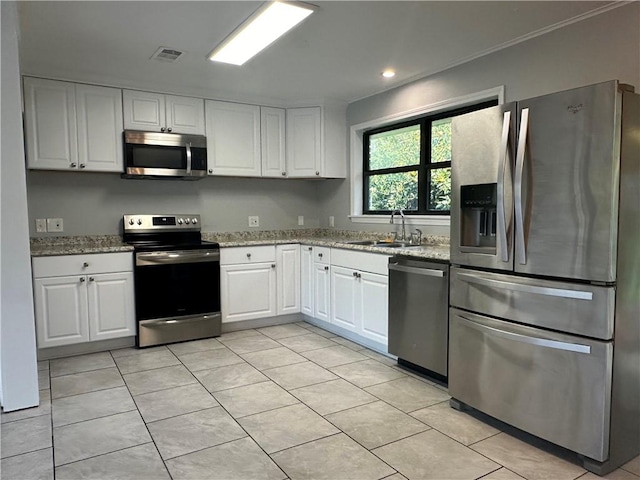 kitchen featuring light stone counters, light tile patterned floors, sink, white cabinetry, and stainless steel appliances