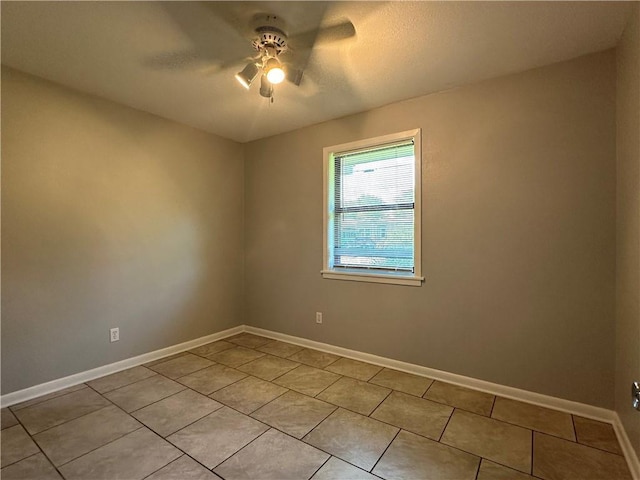 tiled spare room featuring ceiling fan