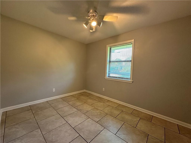 tiled spare room featuring ceiling fan