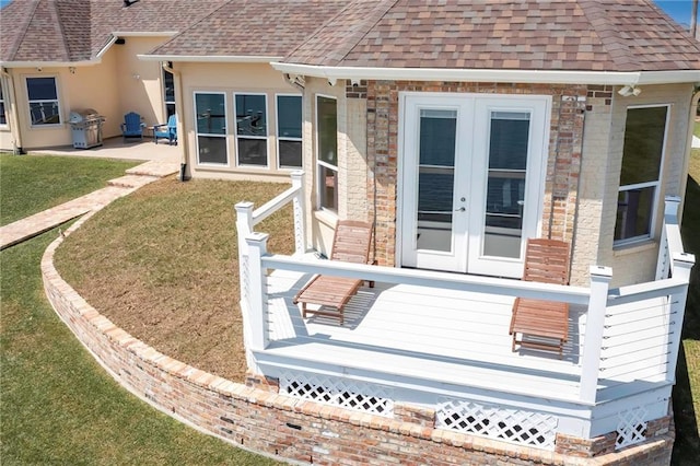 back of house with french doors, a wooden deck, and a yard