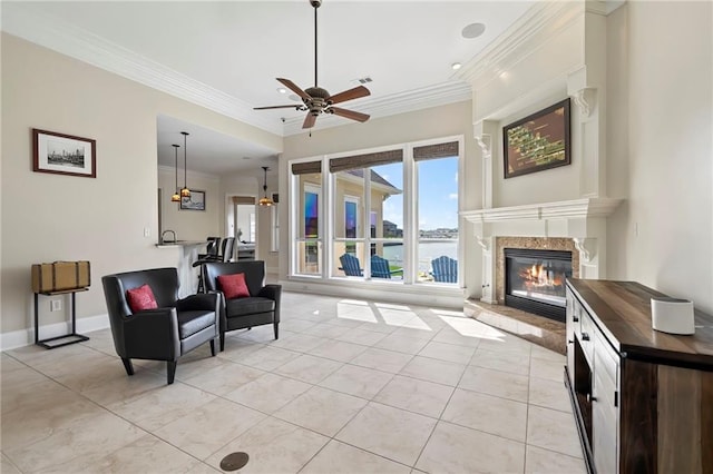 tiled living room featuring a water view, crown molding, and ceiling fan