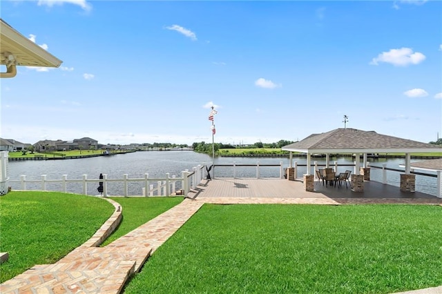 view of dock featuring a gazebo, a patio area, a lawn, and a water view