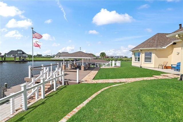 view of dock with a water view and a lawn