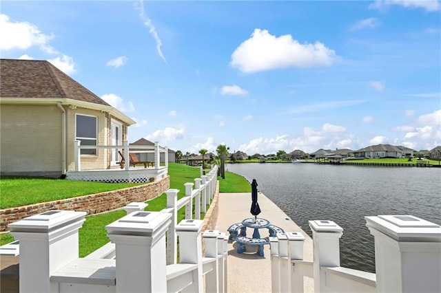 dock area with a lawn and a water view