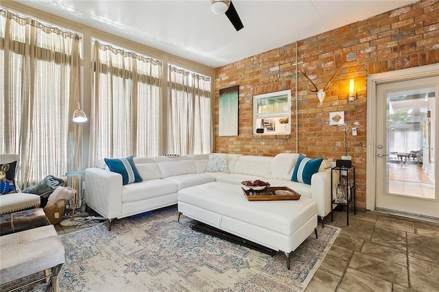 living room featuring brick wall and ceiling fan