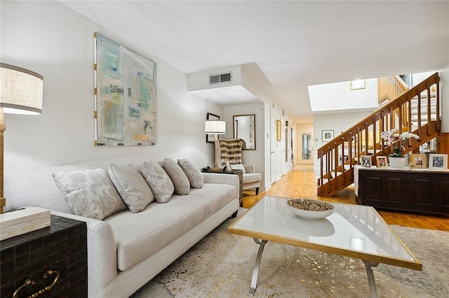 living room featuring a skylight and light wood-type flooring