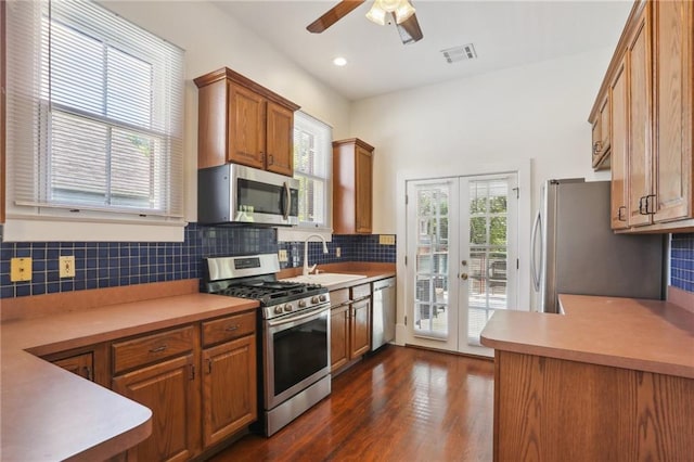 kitchen with sink, appliances with stainless steel finishes, dark wood-type flooring, and decorative backsplash