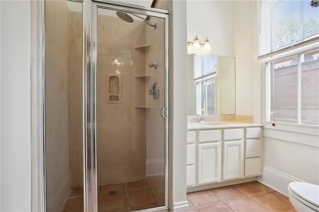 bathroom with vanity, toilet, tile patterned floors, and a shower with door