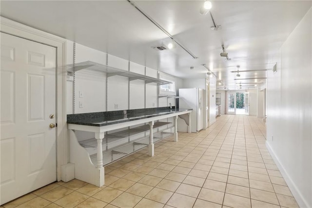 2462 Royal St, New Orleans, LA 70117 - kitchen with a wealth of natural light, white refrigerator, and light tile patterned floors