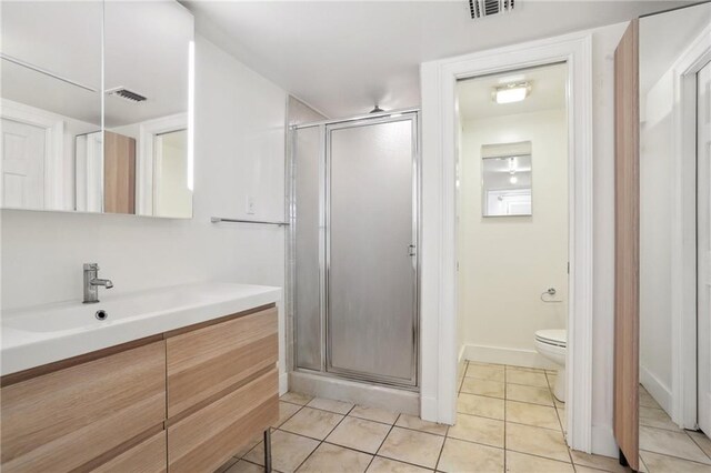 2462 Royal St, New Orleans, LA 70117 - bathroom with tile patterned floors, walk in shower, vanity, and toilet