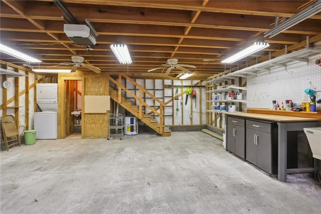 basement featuring a workshop area, ceiling fan, and stacked washer and clothes dryer