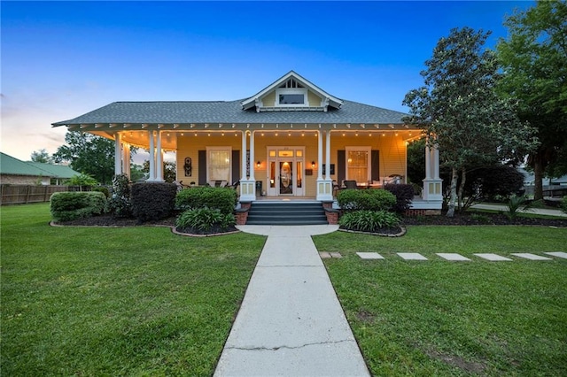 view of front facade featuring covered porch and a yard