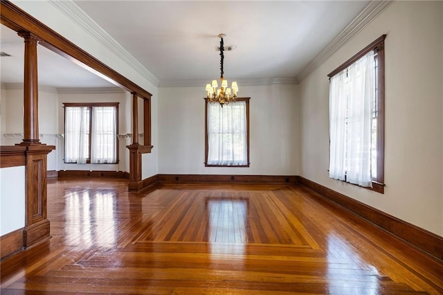 unfurnished room with decorative columns, ornamental molding, parquet flooring, and an inviting chandelier