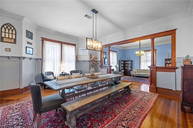 dining room featuring hardwood / wood-style floors, a notable chandelier, crown molding, and a wealth of natural light