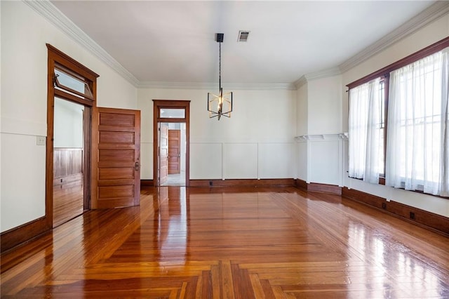 spare room with parquet floors, plenty of natural light, and ornamental molding