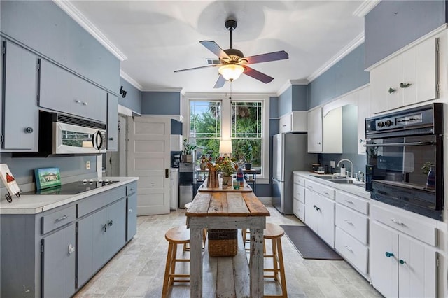 kitchen featuring black appliances, gray cabinetry, ornamental molding, and sink