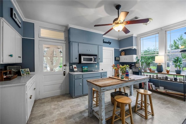 kitchen featuring blue cabinetry, ceiling fan, black electric stovetop, and crown molding