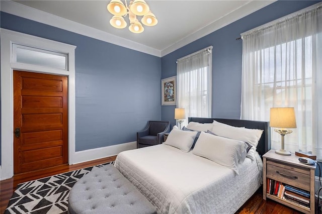 bedroom featuring crown molding, dark wood-type flooring, and a notable chandelier