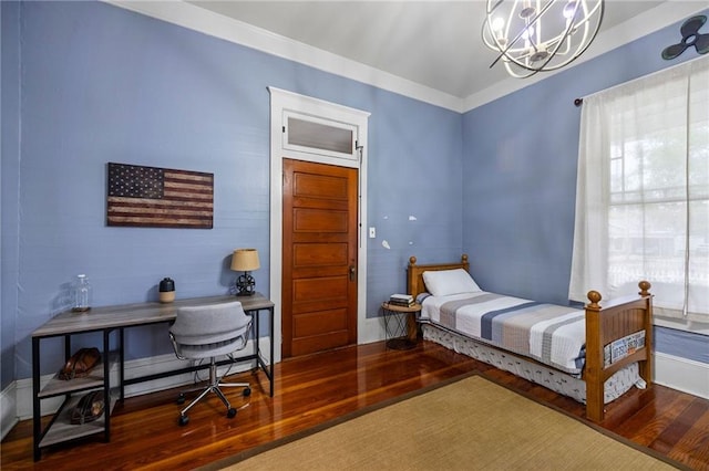 bedroom with hardwood / wood-style floors, ornamental molding, and a chandelier