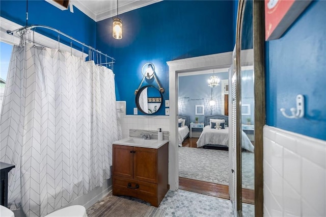 full bathroom featuring hardwood / wood-style floors, shower / tub combo with curtain, vanity, tile walls, and ornamental molding