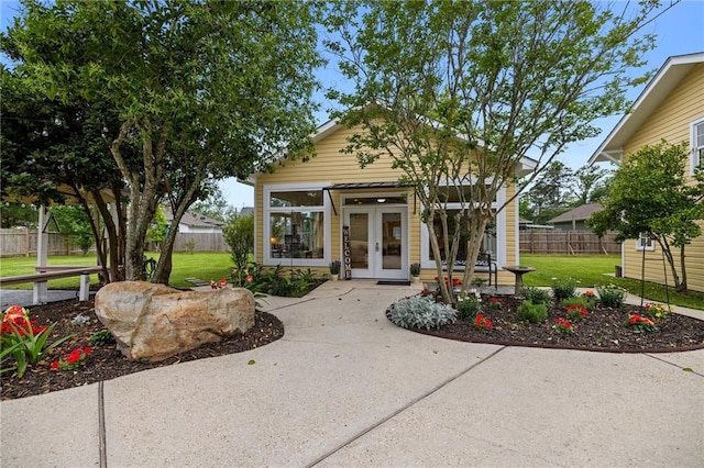 exterior space featuring an outdoor structure, a front yard, and french doors