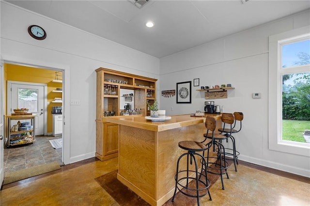 bar featuring plenty of natural light and concrete flooring