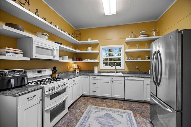 kitchen with white cabinets, white appliances, and sink