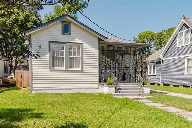 rear view of property with a yard