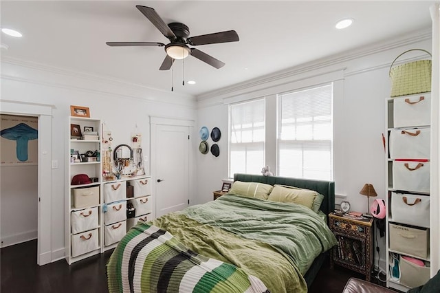 bedroom featuring crown molding, dark wood-type flooring, and ceiling fan