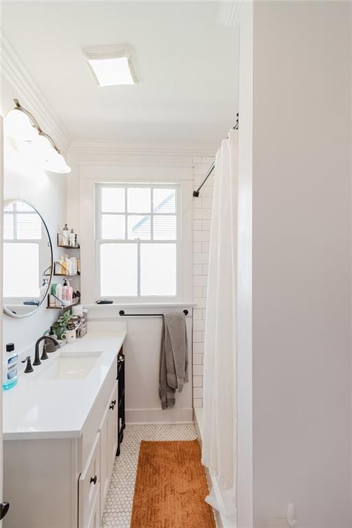 bathroom with walk in shower, vanity, crown molding, and tile patterned flooring