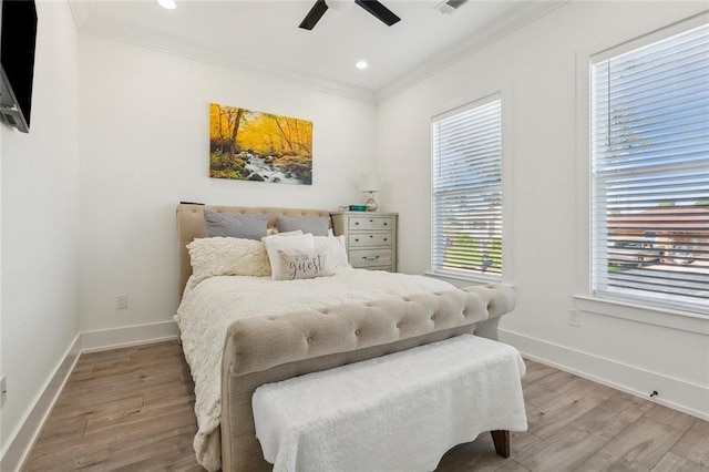 bedroom with crown molding, hardwood / wood-style floors, and ceiling fan