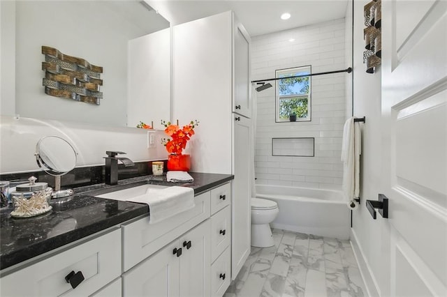 full bathroom featuring tiled shower / bath, vanity, and toilet