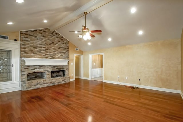 unfurnished living room with wood-type flooring, lofted ceiling with beams, ceiling fan, and a brick fireplace