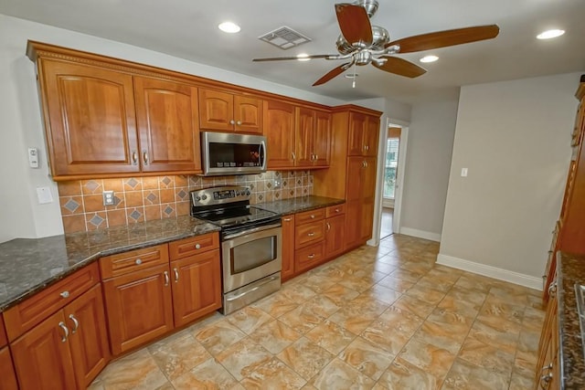 kitchen with appliances with stainless steel finishes, dark stone counters, backsplash, and ceiling fan