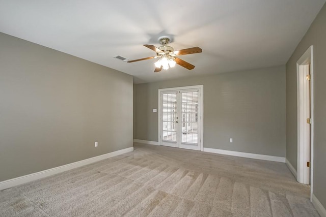 spare room with french doors, light colored carpet, and ceiling fan