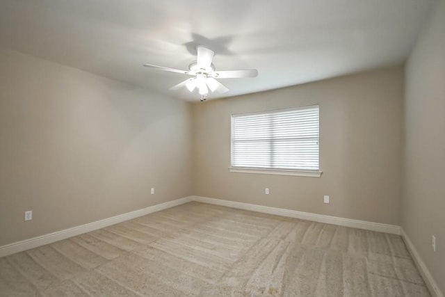 spare room featuring ceiling fan and light colored carpet