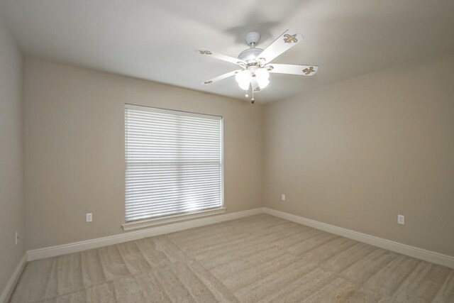 carpeted spare room featuring ceiling fan