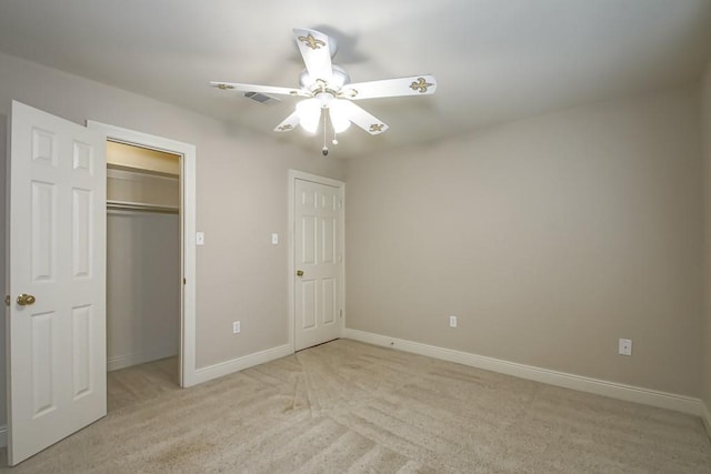 unfurnished bedroom featuring a closet, ceiling fan, and light colored carpet