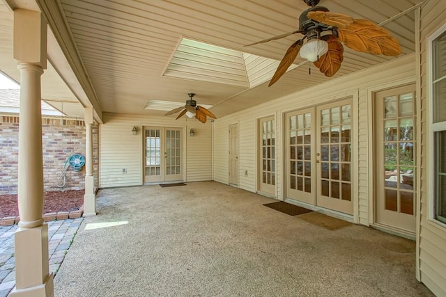 unfurnished sunroom with ceiling fan, ornate columns, and french doors